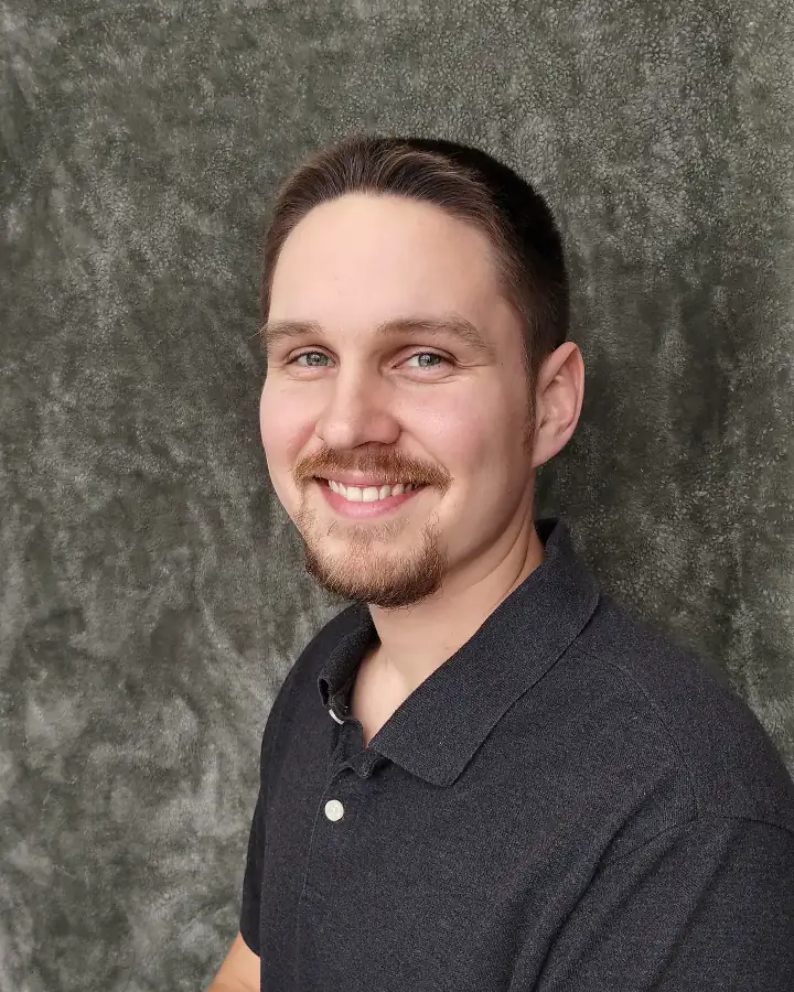 Justin Wiebe, smiling, in a dark polo